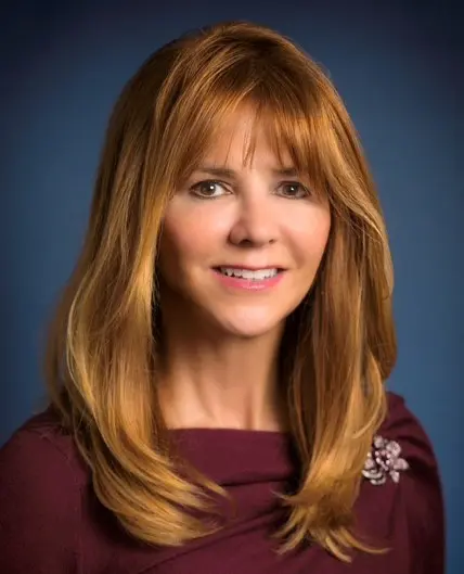 A woman with long red hair and bangs.